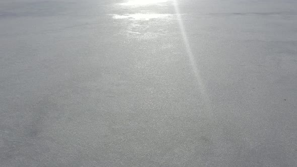 Flying above frozen lake surface by early morning 4K aerial video