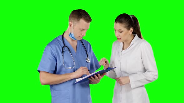 Two Doctors Talking with Clipboard. Green Screen