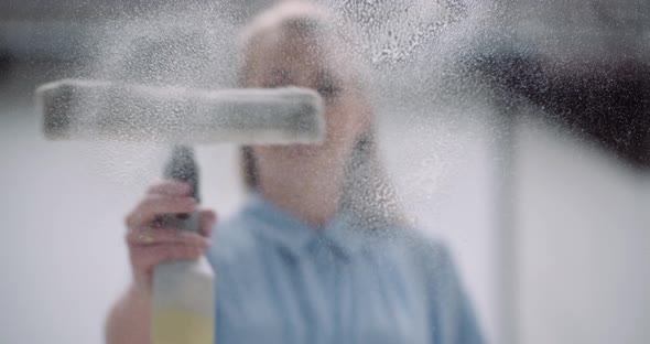 Cleaning - Woman Cleaning Window with Detergents