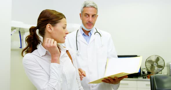 Dentist discussing report with female patient