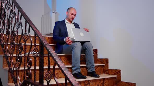 Stressed Businessman Closing Laptop Sighing Sitting on Stairs