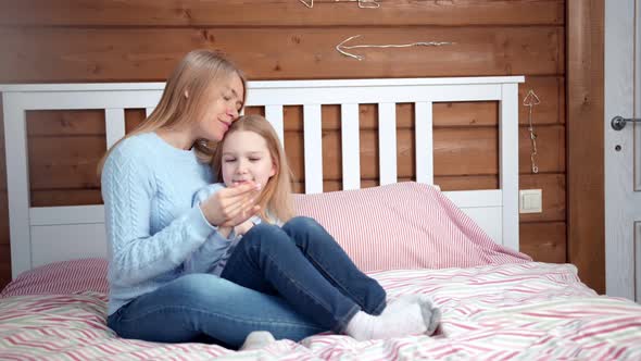 Full Shot Playful Young Mother Enjoying Break Hugging Her Little Daughter By Hands at Home Interior