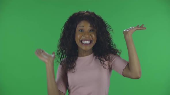 Portrait of Beautiful African American Young Woman Looking at Camera and Performs a Dance of Joy and