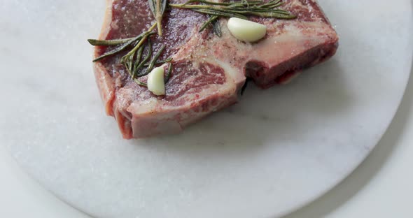 Fresh T-Bone or Porterhouse dry aged steak on marble cutting board. Marinate in olive oil