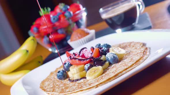 Hot Chocolate is Poured Over Pancakes with Fruit