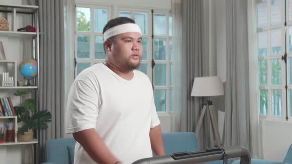 Asian Fat Man Training On Walking Treadmill At Home