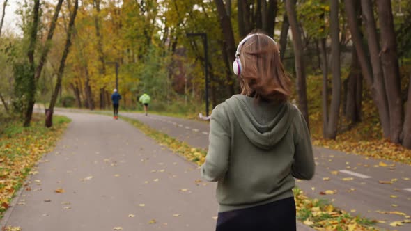 Slow motion woman jogging in park in autumn