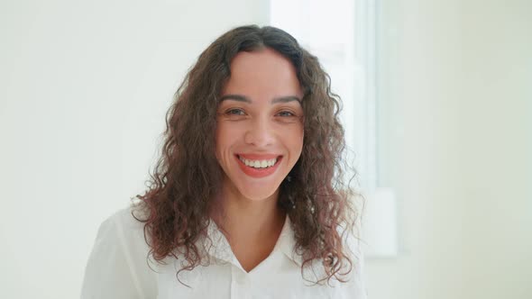 Portrait of Latino woman look at camera after wake up early from bed in bedroom in morning.