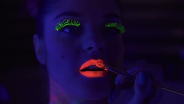 Makeup Artist Uses Brush to Apply Fluorescent Lipstick to Model's Lips