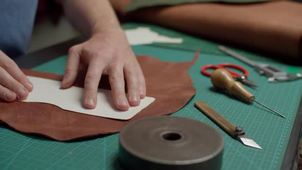 Workshop Worker Applying Template to Leather Piece on Scale Mat Indoor