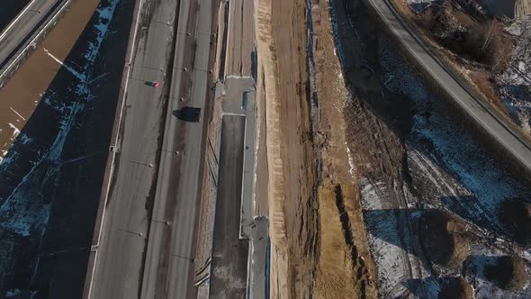 Aerial View of a Moving Black Car on a Highway Under Construction