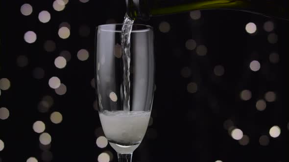 Champagne Poured Into Glass. Bokeh Background