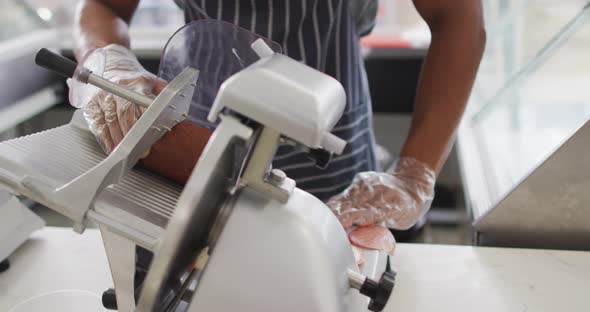 Animation of hands of biracial waiter using meat cutting machine