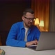 Young Happy Caucasian Manager Sitting in Living Room and Looking at Laptop Rejoices in Successful - VideoHive Item for Sale