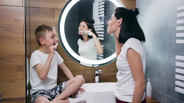  Young Mother which Diligently Cleaning Her Son's Teeth in the Bathroom