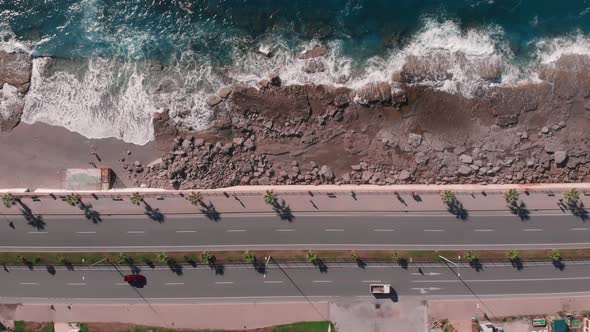 Rocky beach cliff with speed highway and cars. Freeway along sea coast. 