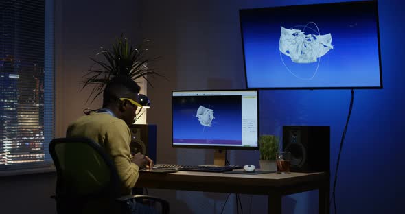 Young Man Sitting Back and Editing an Image on His Computer