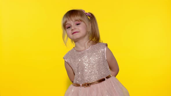 Little Child Girl 5-6 Years Old Smiling, Dancing, Spinning in Place on Yellow Studio Background