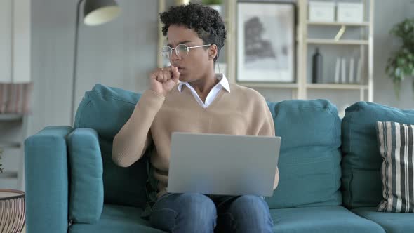 Young African Girl Coughing While Working on Laptop