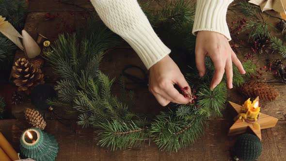 Top view of woman hands making Christmas wreath