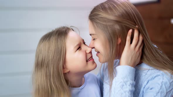 Closeup Cute Baby Girl and Young Woman Rejoicing and Fooling Together Touching Noses Side View