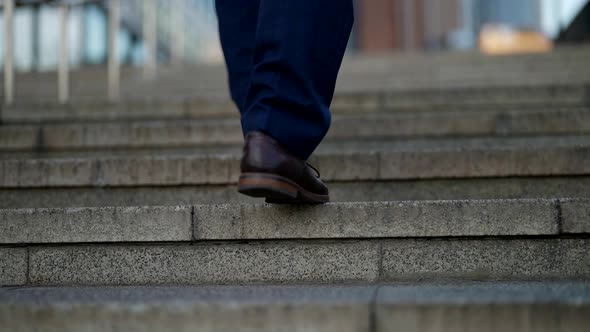 Man Legs are Going Up Over Stone Stairs in City Closeup View Elegant Shoes and Pants