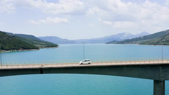 Car Passing Bridge Over Lake