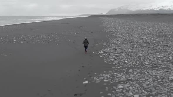 Rising Follow Shot of Woman Running Along a Beach.