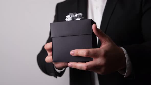 Elegant Black Gift Box in a Man's Hand