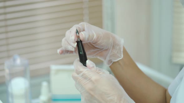 Beautician is Showing a Brush with a Needle at the end in Her Hands for Permanent Makeup