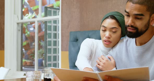 Couple discussing menu card in cafe 4k