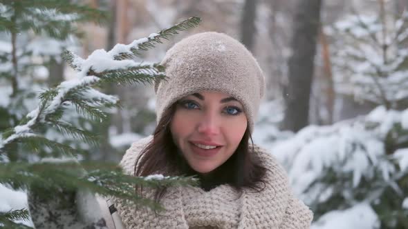 Portrait of a Beautiful Young Girl in a Winter Park Near the Christmas Tree. Slow Motion