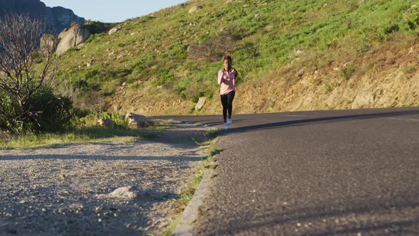 African american woman exercising outdoors running in country side during sunset