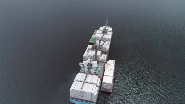 Cargo ship in the sea from behind, drone view