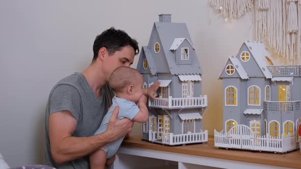 Man Shows Christmas Decorations To His Cute Baby