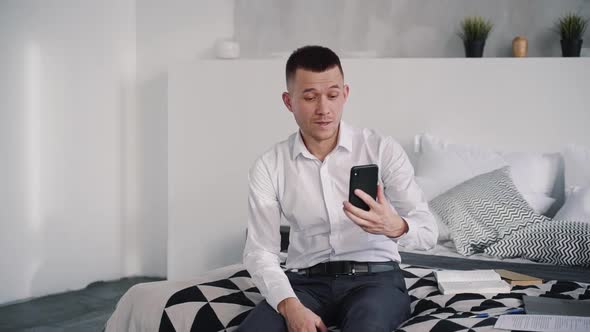 Young Man Sitting at Home, Making Video Chat on Cellular