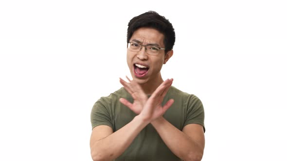 Portrait of Uptight Asian Man 20s Wearing Glasses and Casual Tshirt Shaking Head and Doing Stop