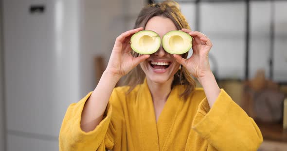 Happy Woman with Avocado in the Morning at Home