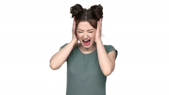 Portrait of Disappointed Woman with Brown Hair in Buns Grabbing Her Head and Screaming in Confusion