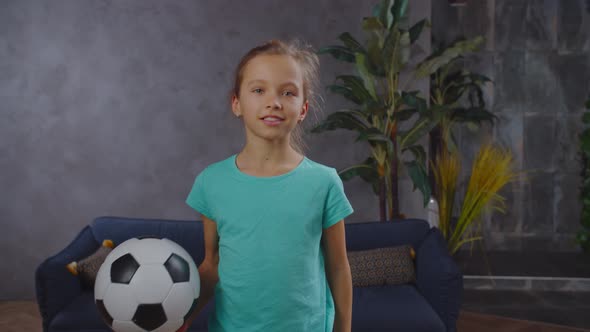 Lovely Little Girl Posing with Soccer Ball Indoor