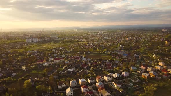 Aerial view of rural area in town with residential houses at sunset summer evening.