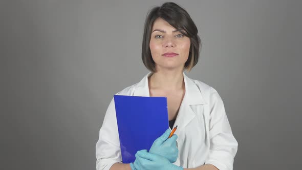 Friendly Young Nurse Holding Folder Isolated on Grey Background