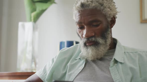 Video of sad african american senior man sitting alone