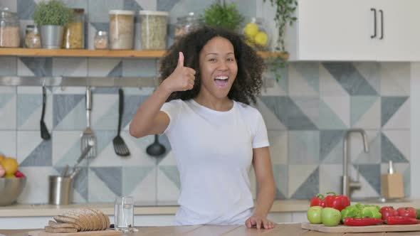 Young African Woman Showing Thumbs Up While Standing in Kitchen