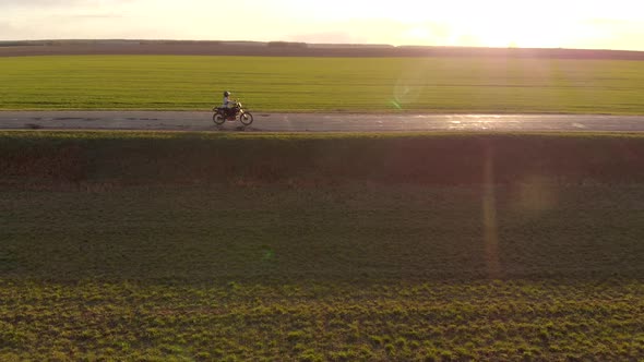 Woman Rides Along a Beautiful Country Road on an Enduro Motorcycle