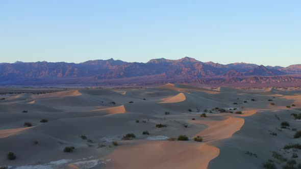 Sunset landscape for travel destination. Death Valley, California. Dunes and mountains in the backgr