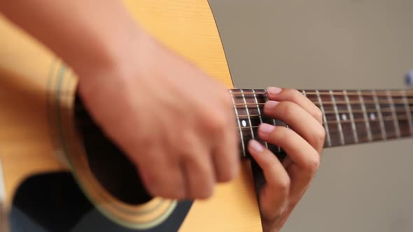 Close up of hand playing acoustic guitar