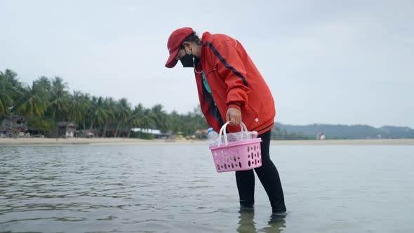 Woman With Basket Looking For Clams In The Sea