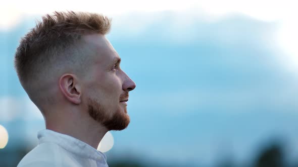 Closeup Face of Smiling Young Man Admiring Amazing Natural Blue Sky at Sunset Rising Up Head