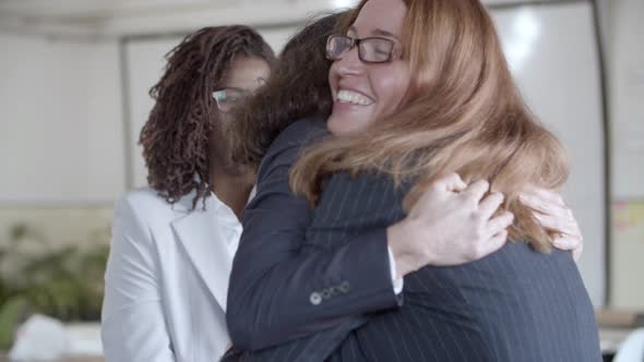 Cheerful Businesswomen Hugging in Office